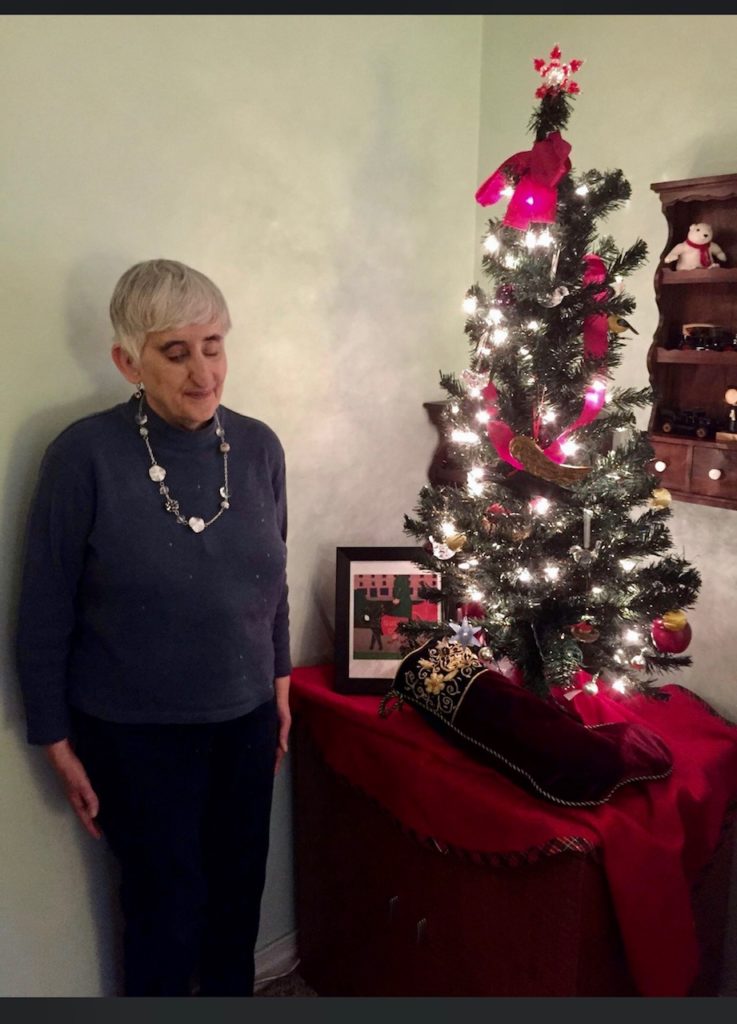 Sandra standing by Christmas tree