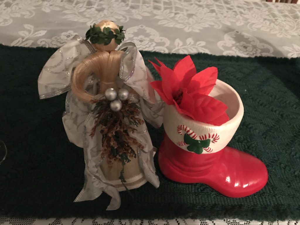 angel statue with white frilly skirt standing next to red ceramic stocking