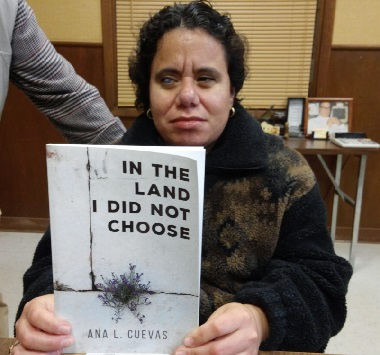 Anna holding up her book "In the Land I did Not Choose"