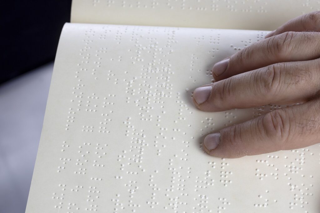 hand on page with braille 